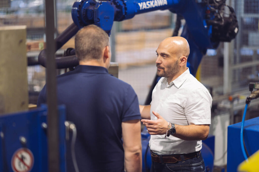 Beratungsgespräch zum Arbeitsschutz in einer Produktionshalle